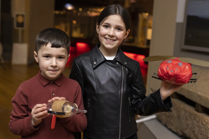 Two children holding crafty creatures