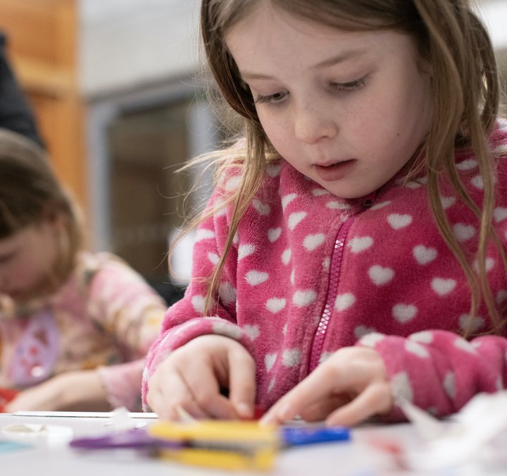 A young child is crafting at a table