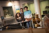 A mum, daughter and son look at objects in the gallery