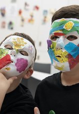 Two children are making masks.