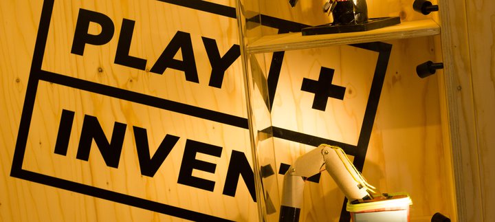 Image of wooden panel stamped with PLAY + INVENT