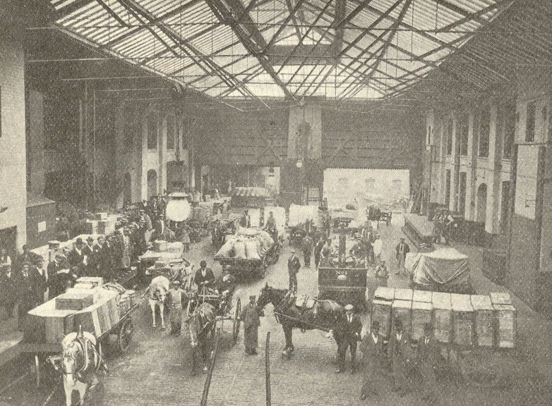 Blandford House Loading Bay a group of men with horse and carts bring in goods under a glass ceiling 