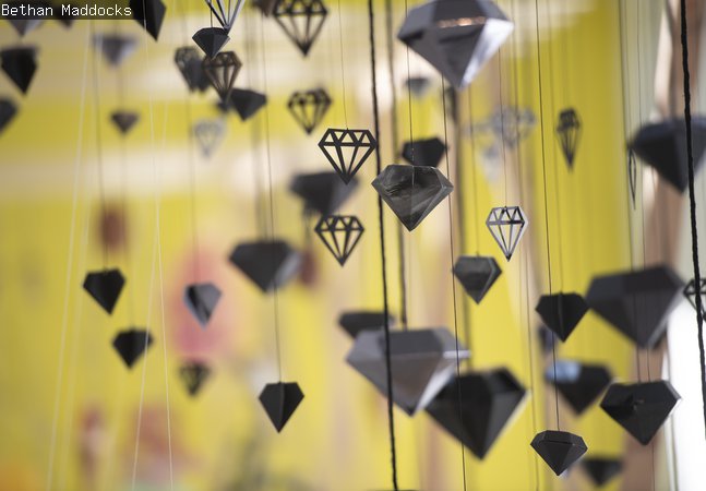 Black diamonds of paper and card hanging by threads