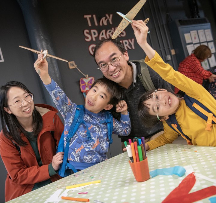 Family group with parents and two children smile at camera  
