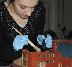 Conservation team cleaning a model