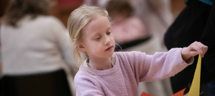 A girl with long blonde hair taking part in a craft activity