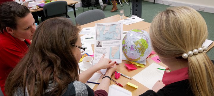 Three women look at a training resource