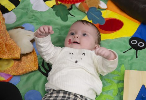 A baby is laying on a sensory mat.