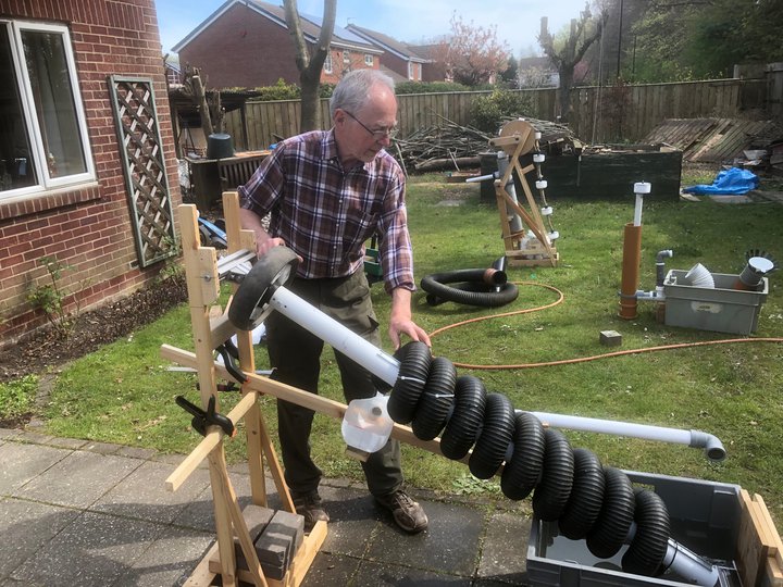 Photograph of a man demonstrating how a water screw turbine works