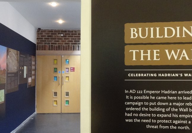Information panels on wall by the entrance to an exhibition gallery