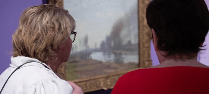 Two people viewing the Monet artwork
