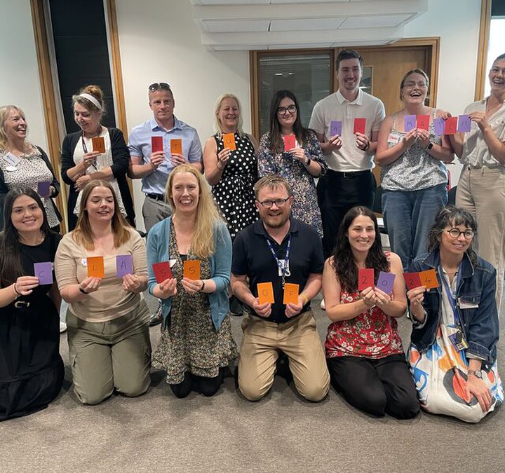 A group of teachers smiling for photographs