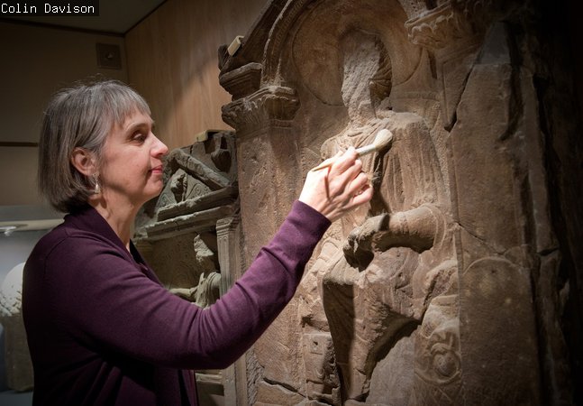 Curator brushes the Regina headstone 