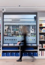 colourful shop shelves with a blurry image of a person walking past