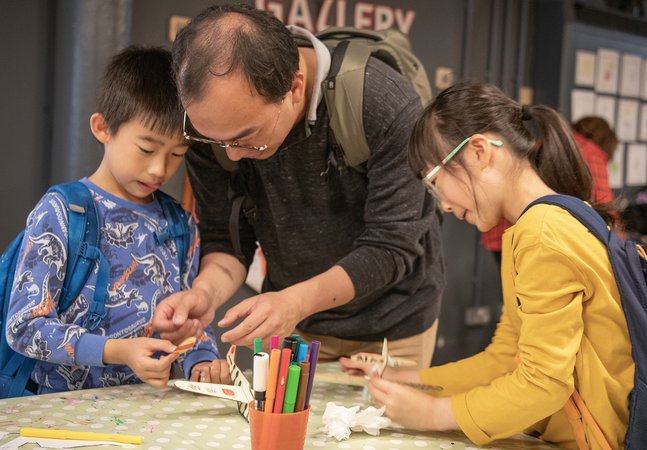 Dad and two children engrossed in craft