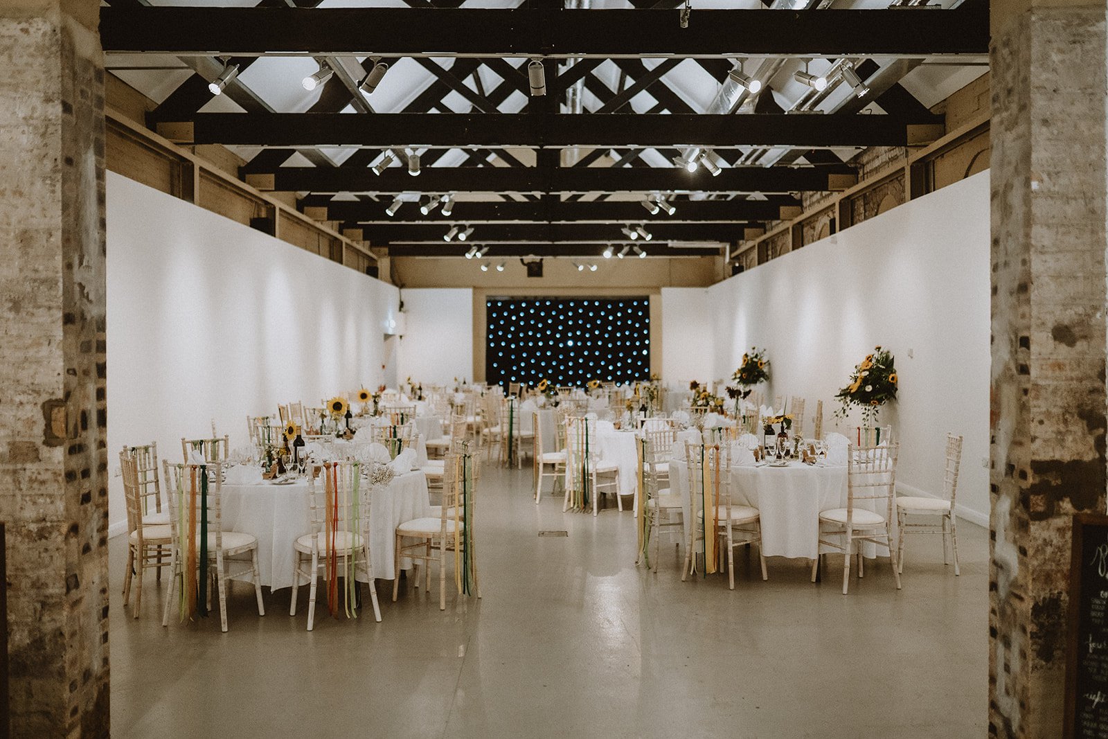 A large room with tables and chairs set up for an event A large room with tables and chairs set up for an event