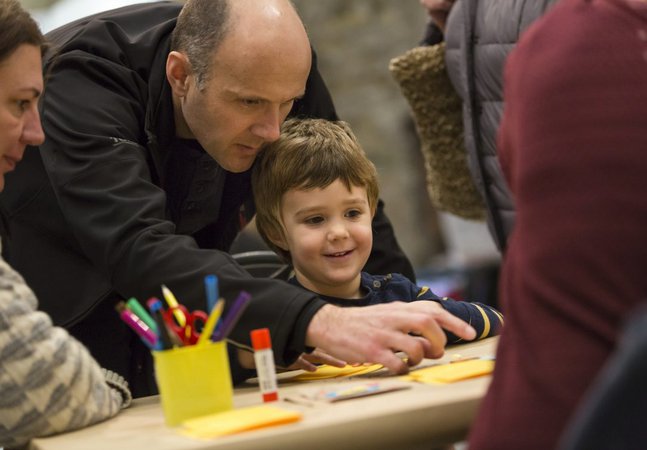 A father and son are sat at a craft table 