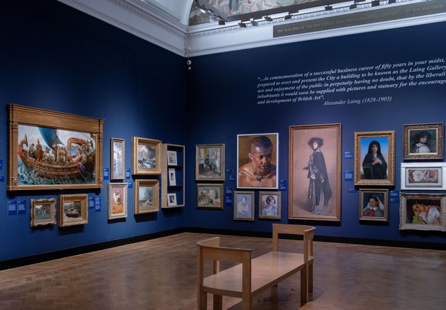 A photograph of the inside of an art gallery with oil paintings in gold frames.