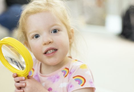 A young girl with a magnifying glass