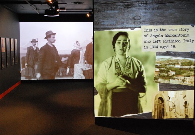 Photo of the large screen showing migrant stories in 