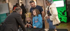 A family is engaging with a museum curator 