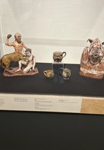 A glass display cases with a selection of ceramic objects. The label for the cases reads 'Myths and Legends' in black text on a cream background.