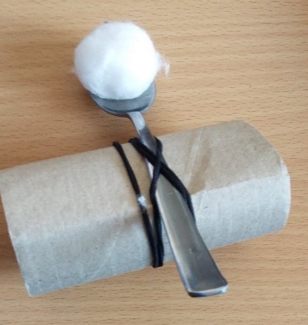 Spoon catapult loaded with cotton wool ball