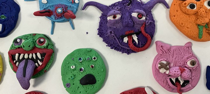 Different shaped, colourful monsters made out of clay.