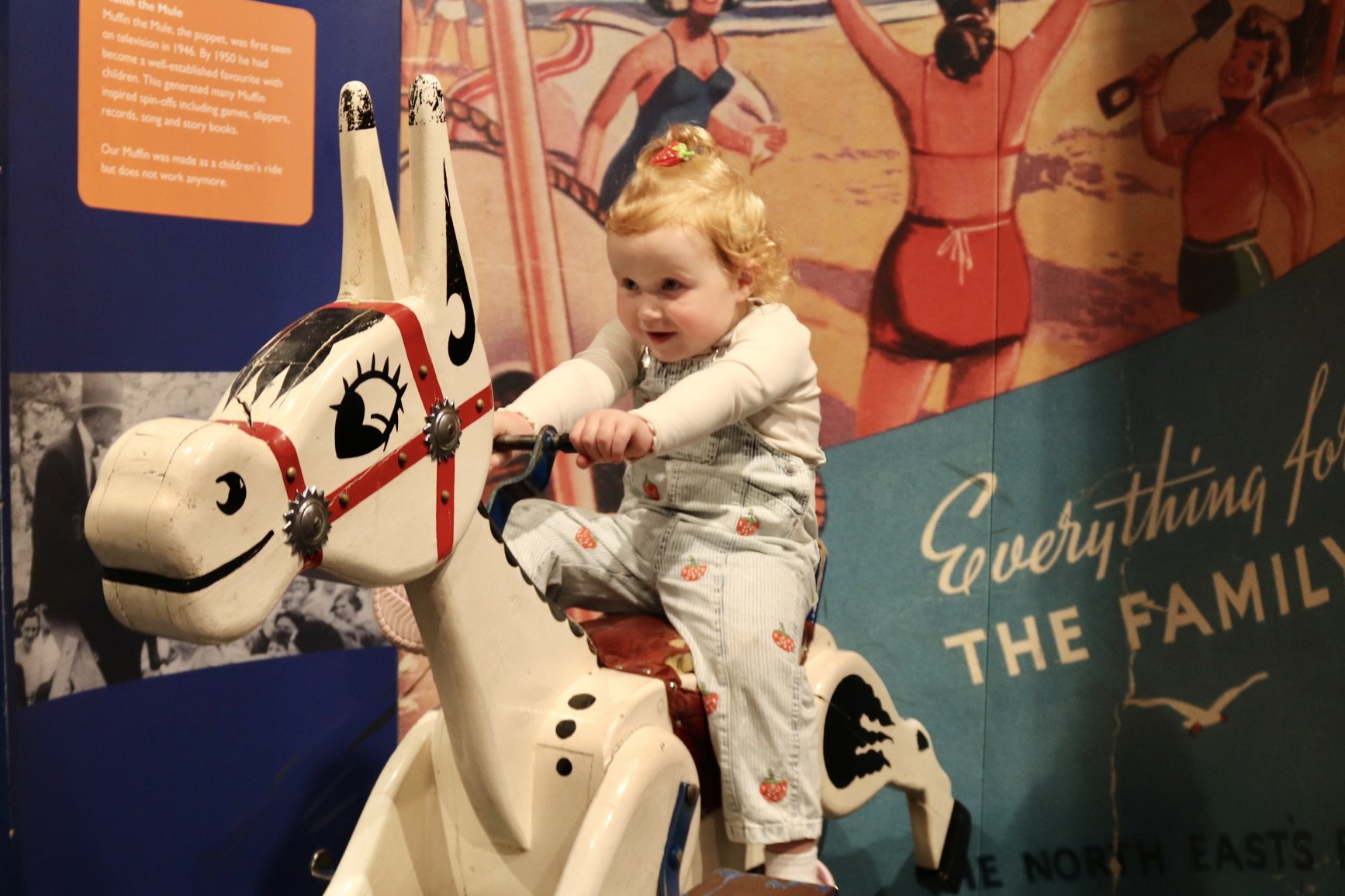 Child riding wooden donkey Child riding wooden donkey