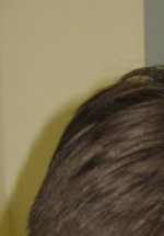 Back view of someone using a loupe to examine an object
