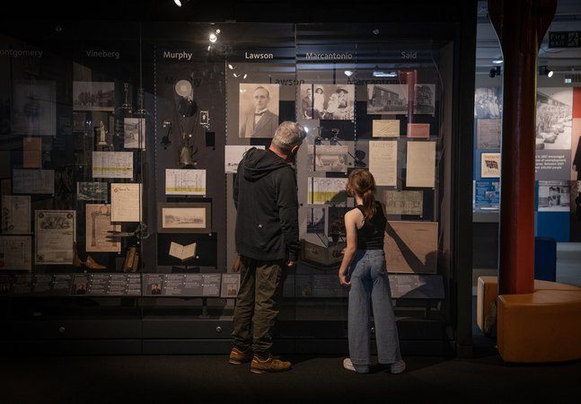 Dad and daughter look in cabinet of migration stories 