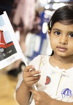 litle girl wavs flag in museum
