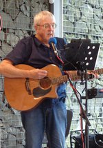 Two men playing guitar and banjo on a stage 