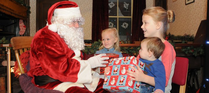 Santa meeting three children and giving them gifts