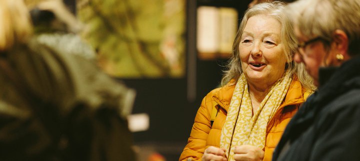 women smile and laugh together in gallery