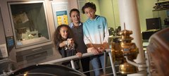 A mum, daughter and son look at objects in the gallery