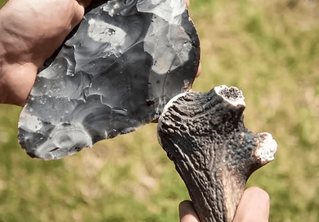 A persons hand are Flintknapping.