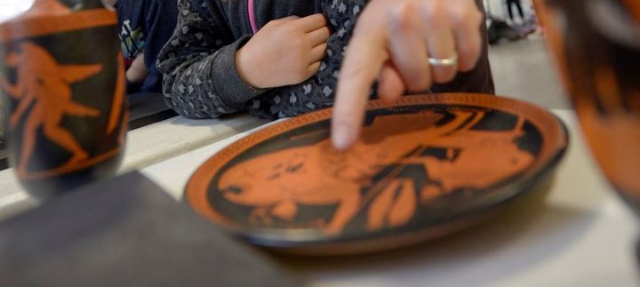 Curator Andrew Parkin shows a Greek bowl to visitors