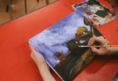 A young person painting on a canvas.