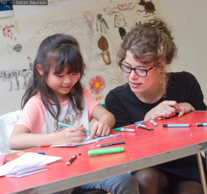 Young girl talking to an art educator