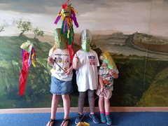 Three young children wearing handmade cavalry style masks