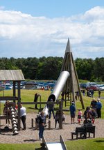 An outdoor playground with parents and children playing
