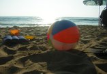 Ball on a beach next to a bucket and spade