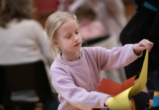 A girl with long blonde hair taking part in a craft activity
