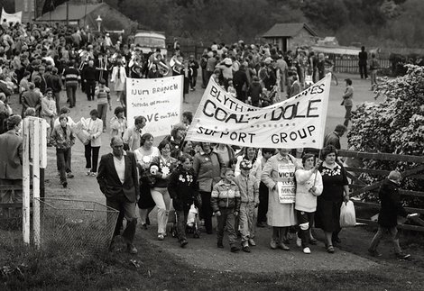 A crowd of people marching with banners.