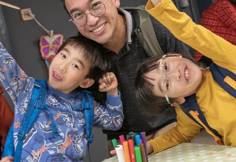 Family group with parents and two children smile at camera  