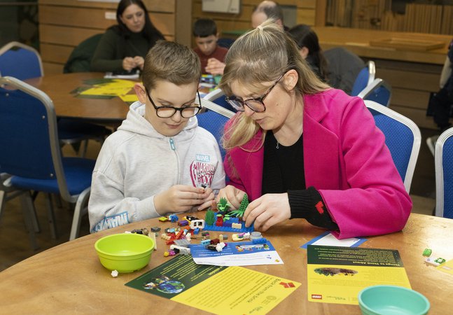 A adult and a child doing a LEGO activity. 