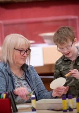 A photograph of a mum and child doing crafts together.