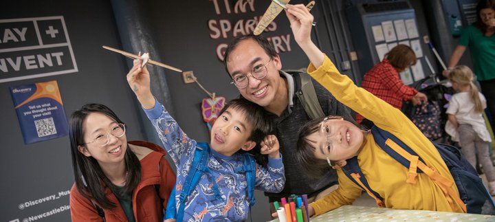 Family group with parents and two children smile at camera