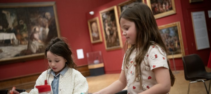 Two children taking part in a craft activity together.